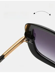 Detail of durable gold metal hinge on square black sunglasses with purple gradient lenses