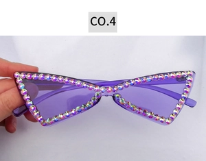 Détail de lunettes de soleil œil-de-chat sans monture avec verres violets et strass