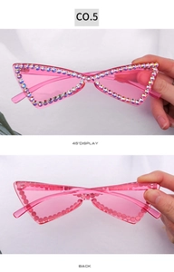 Détail macro de lunettes œil-de-chat sans monture avec strass irisés et verres roses