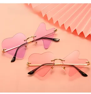 Close-up of heart and arrow-shaped rimless sunglasses in pink and orange tones