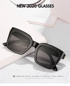 Close-up of square black sunglasses with silver metal hinge accents on white blocks