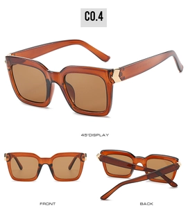 Detail view of square amber sunglasses featuring gold arrow accents and tinted lenses
