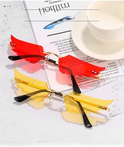 Détail de lunettes de soleil sans monture en forme d'aile, rouge et jaune, métal doré