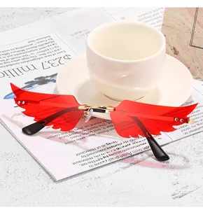 Gros plan sur des lunettes de soleil rouges en forme d'ailes avec monture dorée