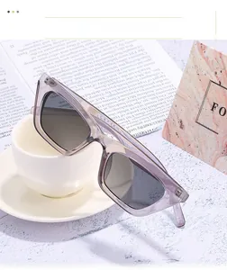 Detail of translucent purple cat eye sunglasses placed on a white coffee cup rim