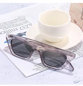 Retro small cat-eye sunglasses with gray lenses on a magazine and coffee cup background
