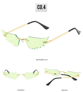 Détails de lunettes de soleil en forme d'ailes avec verres verts et monture dorée