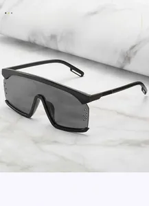 Details einer übergroßen Shield-Sonnenbrille mit dunklen Gläsern und modischen Nieten