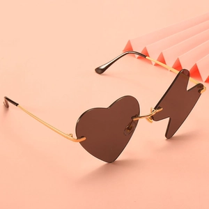 Funny asymmetrical sunglasses with heart and lightning lenses on a pink background
