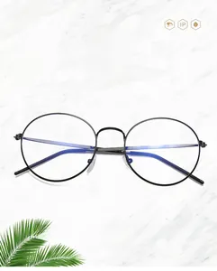 Detail of round metal glasses frame featuring anti-blue light lenses on marble background