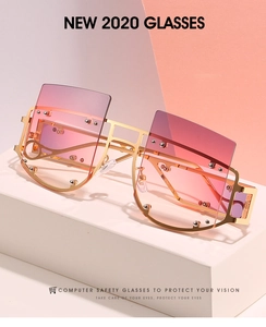 Detail of oversized gold metal sunglasses with studded temples and gradient purple lenses