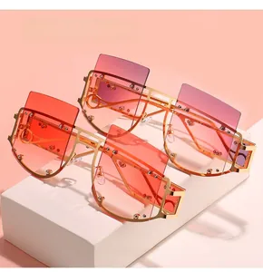 Detail of trendy oversized square sunglasses with gold metal frames and gradient lenses