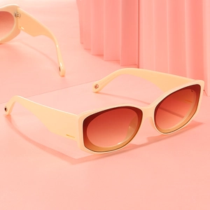 Lunettes de soleil carrées crème avec verres dégradés orange sur fond rose chic