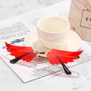 Lunettes de soleil rouges en forme d'ailes avec pont doré et branches noires