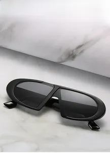 Gros plan de lunettes de soleil noires tendance à monture étroite sur fond de marbre