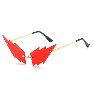 Futuristic red lightning-shaped sunglasses with golden metal frame on white background
