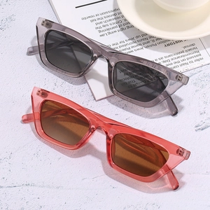 Trendy cat-eye sunglasses in translucent jelly colors on a modern textured surface