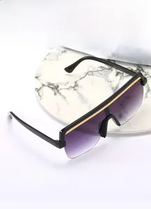 Close-up of oversized sunglasses with purple gradient lenses and gold chain link top bar