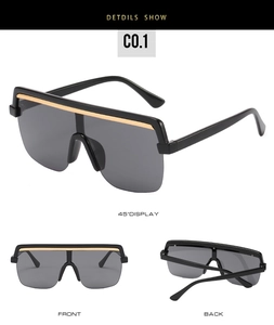 Detailed view of oversized sunglasses with black frame and golden top bar accent