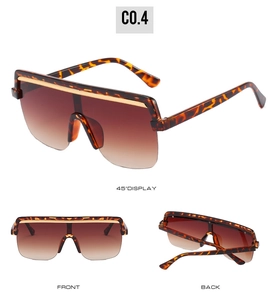 Detail view of oversized tortoise shell shield sunglasses with gold top bar decoration