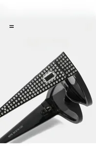 Detailed close-up of rhinestone-encrusted temples on black cat-eye sunglasses