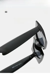 Vue macro de lunettes de soleil noires montrant les charnières et spécifications du modèle