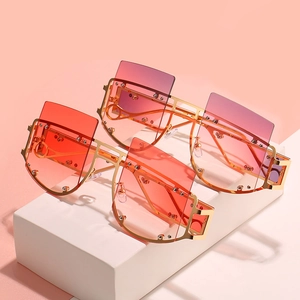 Oversized square rivet sunglasses with rimless gold frames in red and purple gradient lenses