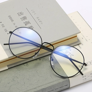 Retro black round metal eyeglasses frame with anti-blue light lenses on books