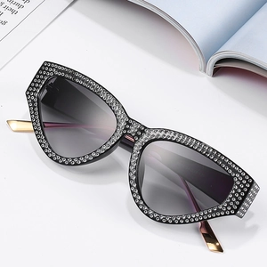Luxury cat-eye sunglasses with rhinestone-studded black frames and gold metal temples