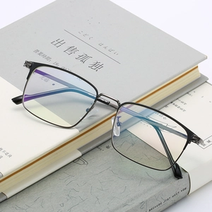 Classic black square optical glasses frame resting on books in a professional setting
