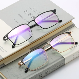 Modern square anti-blue light glasses with sleek black and gold metal frames on books