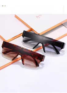 Close-up of oversized square sunglasses in black and tortoiseshell on a textured gift box