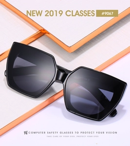 Detail einer geometrischen Cat-Eye-Sonnenbrille mit dunkelgrauen Gläsern auf Display