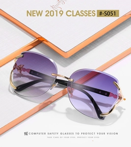 Detail of rimless purple gradient sunglasses with gold metal fox head decor and black temple