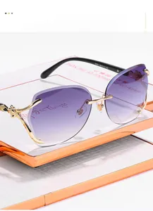 Close-up of golden leopard head detail on rimless gradient purple sunglasses lenses