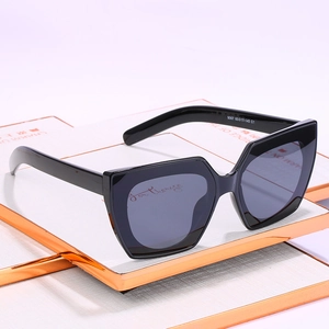 Modische schwarze geometrische Cat-Eye Sonnenbrille mit grauen Gläsern auf weißem Sockel