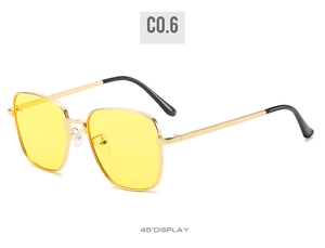 Detail of square gold metal sunglasses with yellow lenses and black temple tips