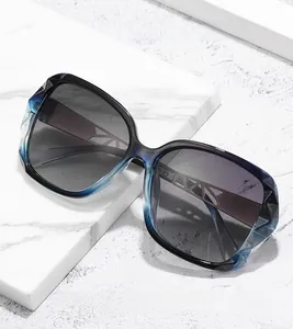 Detail of luxury oversized sunglasses featuring blue marble frames and geometric metal temples