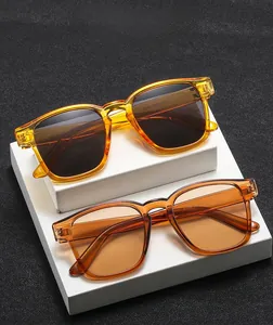 Close-up of retro square sunglasses in tea brown and orange frames on a geometric stand