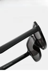 Detail shot of black thick-frame sunglasses temple showing size 53-20-145 and CE mark