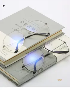 Detail of silver and gunmetal aviator glasses frames with blue light coating on books