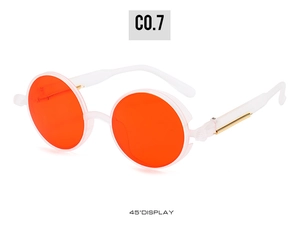 Detail of steampunk sunglasses with orange lenses and gold metal spring hinge accents