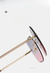 Close-up of frameless gradient sunglasses with gold metal chain temple design