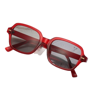 Square red transparent frame sunglasses with black lenses and gold metal accents