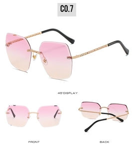 Detail view of rimless square sunglasses with pink gradient lenses and golden chain temples