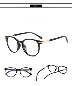 Close-up of cat-eye black frame with detailed gold metal hinges and engraved patterns