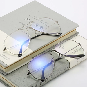 Classic pilot eyeglasses with silver and dark grey metal frames on books
