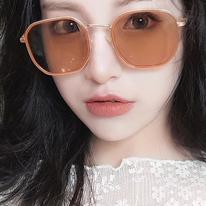 Gros plan de lunettes de soleil polygonales en métal avec verres teintés ambre