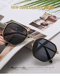 Détail de lunettes de soleil hexagonales en métal doré avec verres foncés chic