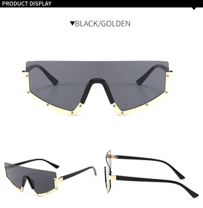 Detail view of oversized sunglasses with black frame, golden metal rim and screw accents